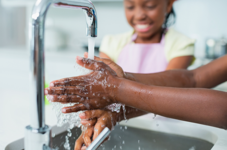 Two people washing their hands to prevent infection and disease.